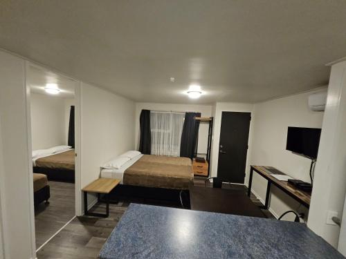a small hotel room with a bed and a television at Rockfield Motel in Auckland