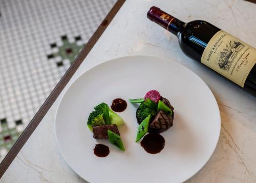 a white plate with food and a bottle of wine at Hotel Indigo Nagasaki Glover Street by IHG in Nagasaki