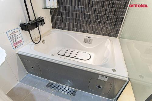 a bath tub in a bathroom with a shower at Hotel Maru in Seoul