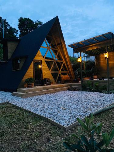 a house with a black roof and a gravel yard at Glamping de la Montaña in Girardota