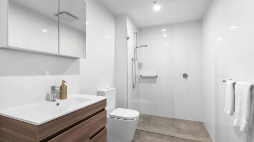 a white bathroom with a toilet and a shower at Allura Blue by Experience Jervis Bay in Huskisson