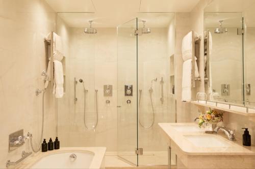 a bathroom with a shower and two sinks and a tub at Egerton House in London