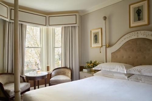 a bedroom with a bed and a desk and a window at Egerton House in London