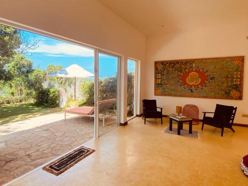 a living room with a large glass door with a view at Belika Beach in Hiriketiya