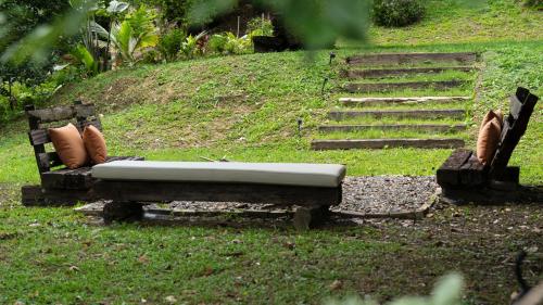 a bench sitting in the grass next to a staircase at Casa Adobe Finca in La Peña