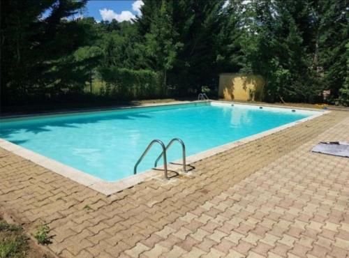 une grande piscine avec de l'eau bleue dans l'établissement Mobil-home vacances Lozère, à Banassac