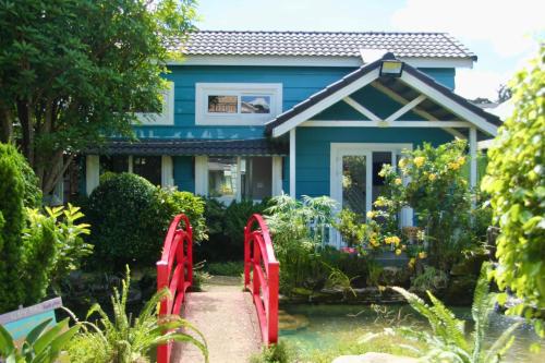 a blue house with red gates in front of a garden at Homestay Đà Lạt - The November Stay in Da Thanh