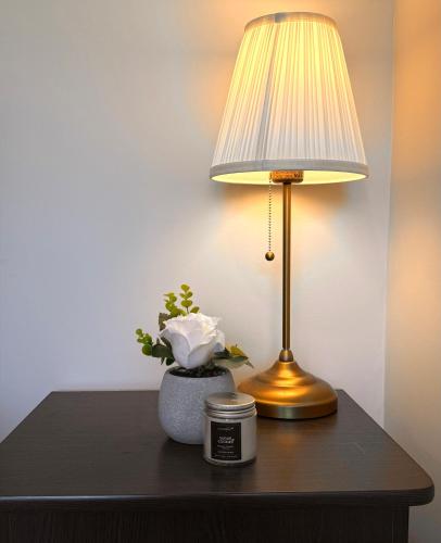 a table with a lamp and a vase with a plant at Downtown Huntsville Gem in Muskoka in Huntsville