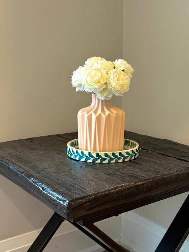 a vase filled with flowers on a table at Downtown Huntsville Gem in Muskoka in Huntsville