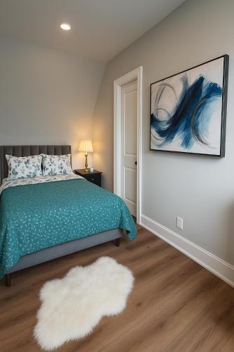 a bedroom with a green bed and a white rug at Downtown Huntsville Gem in Muskoka in Huntsville