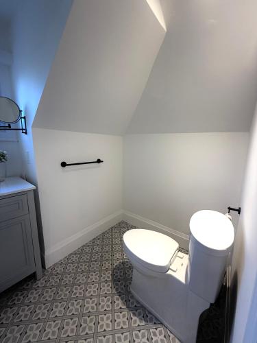 a white bathroom with a toilet and a sink at Downtown Huntsville Gem in Muskoka in Huntsville