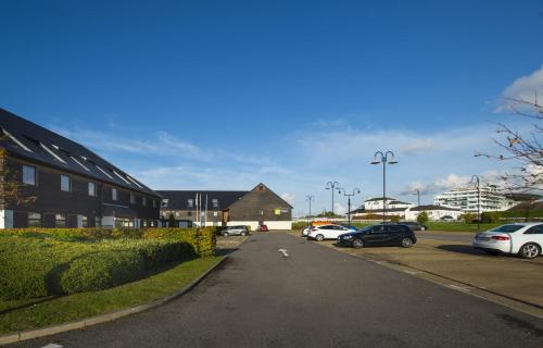 a street with cars parked in a parking lot at Holiday Inn Express London - Epsom Downs by IHG in Epsom