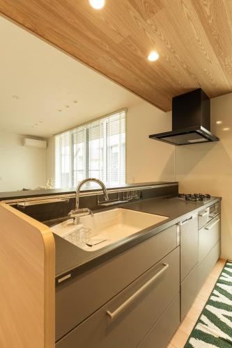 a kitchen with a large sink and a window at Mova Villa Koshi 大和 4 - エレベーター 無料駐車場付 一軒家貸切 in Yuge