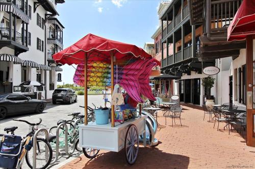 a hot dog cart with a red umbrella on a street at Sans Souci by 30A Escapes in Seacrest