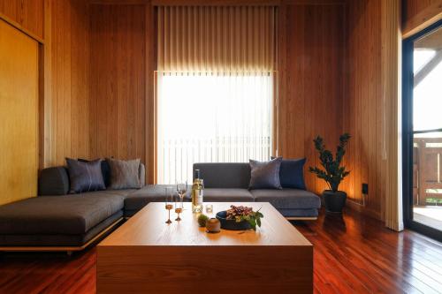 ein Wohnzimmer mit einer Couch und einem Couchtisch in der Unterkunft オーシャンビュー BBQ可 最大8名 自然を満喫できる宿 Maru in Motobu