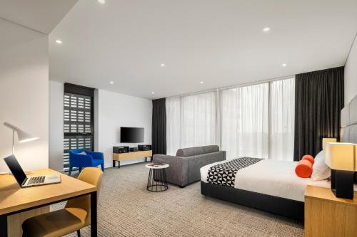 a hotel room with a bed and a desk at Quest St Leonards in Sydney