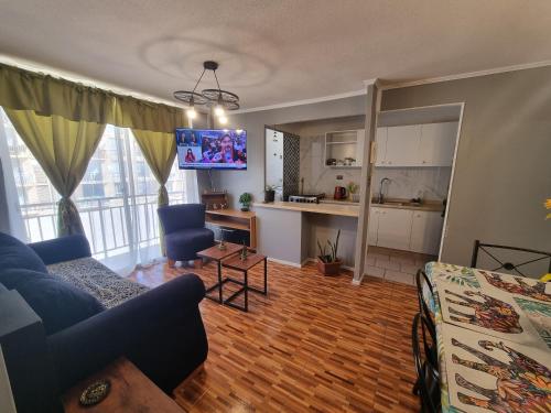 a living room with a couch and a kitchen at Depto II wheelwright Rdkl in Copiapó