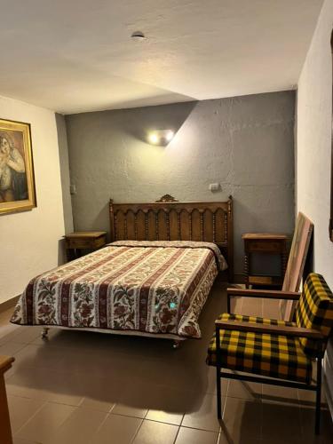 a bedroom with a bed and a couch and a chair at La Gregoria in Carpintería
