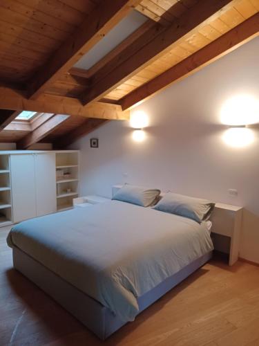 a bedroom with a large bed and wooden ceilings at Penthouse in the green with private pool and garden in Portula
