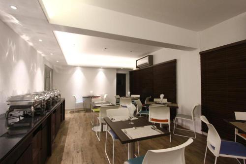 a dining room with tables and white chairs at Spring Hill Hotel and Service Apartments in Dhaka