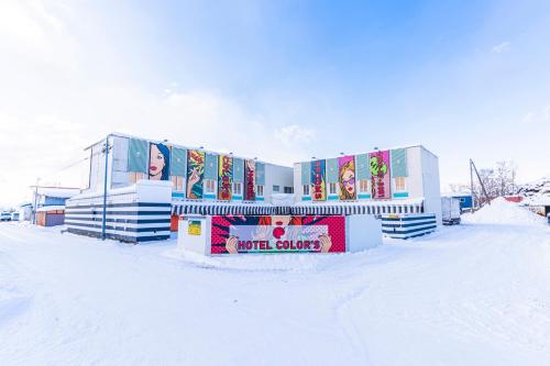 a building with snow on the ground in front of it at Asahikawa Hotel COLOR'S-Adult Only in Asahikawa