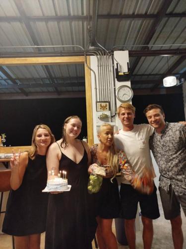 a group of people posing for a picture with a birthday cake at Koh Tao Silver Na’s Hostel in Koh Tao
