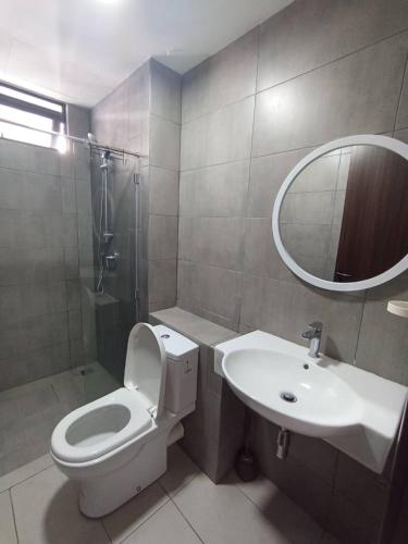 a bathroom with a toilet and a sink and a mirror at K Avenue by Pinstay in Donggongon