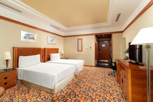 a hotel room with a bed and a television at Holiday Inn Kuwait by IHG in Kuwait