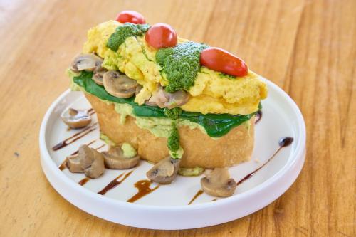 a breakfast sandwich with mushrooms and tomatoes on a plate at Community Hostel Quito in Quito