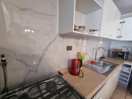 a kitchen with white cabinets and a red appliance on a counter at Depto II wheelwright Rdkl in Copiapó
