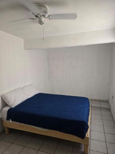 a bed in a room with a ceiling fan at Alojamiento entero in Los Mochis