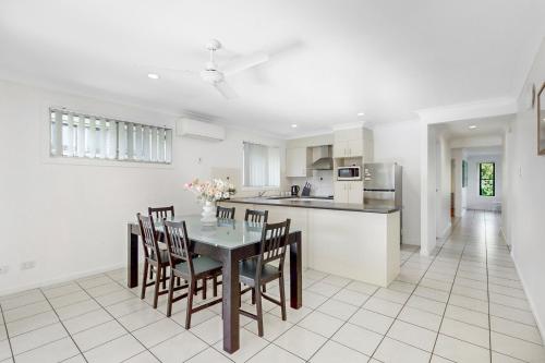 a kitchen and dining room with a table and chairs at Golden Moments Family Stay in Gold Coast