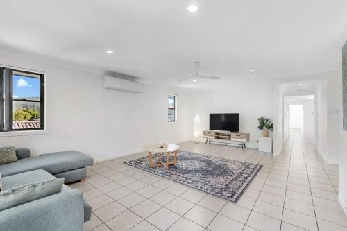 a living room with a couch and a tv at Golden Moments Family Stay in Gold Coast