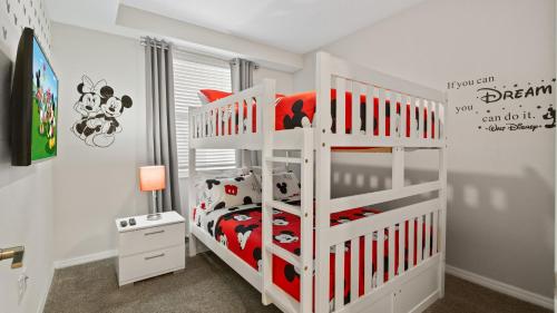 a white bunk bed in a white room with a bed at Beautiful Apartments 5 Minutes away from Disney! in Kissimmee