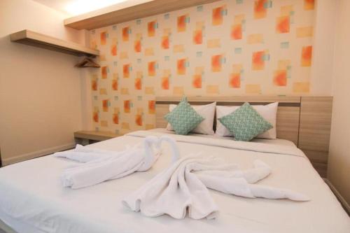 a bedroom with a bed with white towels on it at Klang Muang @ Nongkhai Hotel in Nong Khai
