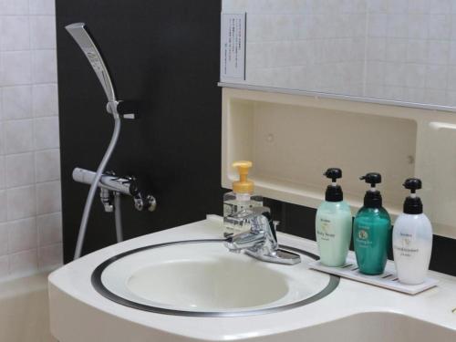 a bathroom sink with two bottles of soap on it at Oita Century Hotel in Oita