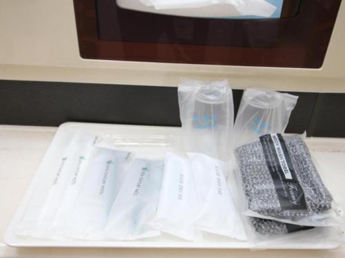 a table with white plastic bags and a remote control at Oita Century Hotel in Oita