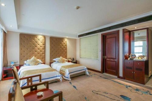 a hotel room with two beds and a sink at Jincheng Pacific Hotel in Jincheng