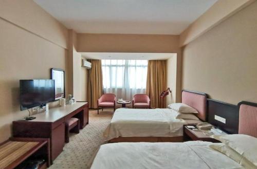 a hotel room with two beds and a flat screen tv at Quanzhou Royal Prince Hotel in Quanzhou