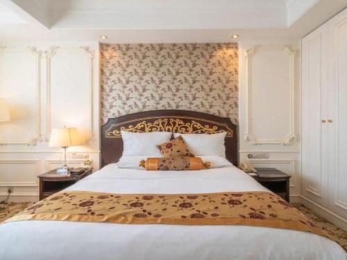 a bedroom with a bed with a teddy bear on it at Jinjiang Grandlink Hotel in Quanzhou