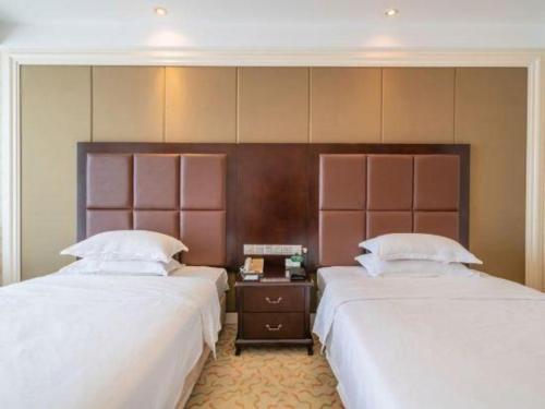 two beds sitting next to each other in a room at Jinjiang Grandlink Hotel in Quanzhou