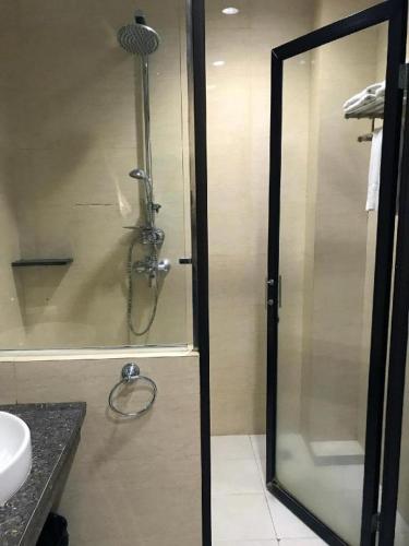 a shower with a glass door in a bathroom at Mega Permata Hotel in Padangsidimpuan