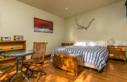 1 dormitorio con cama, mesa y escritorio en Misty River Retreat, en Blenheim