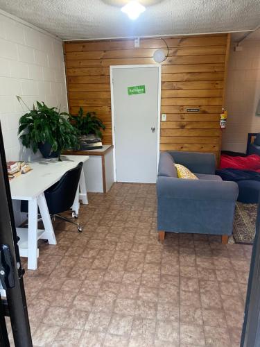 a room with a door and a table and a couch at Bay of Islands Lodge in Paihia