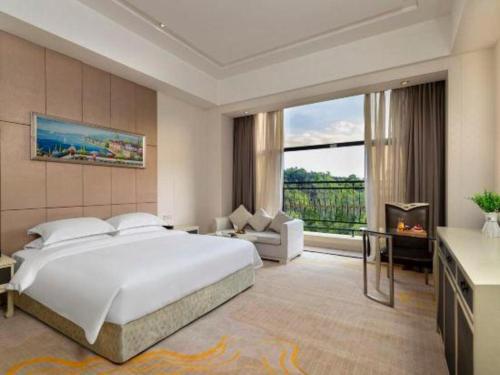 Ένα ή περισσότερα κρεβάτια σε δωμάτιο στο Shenzhen Jin Mao Yuan Hotel