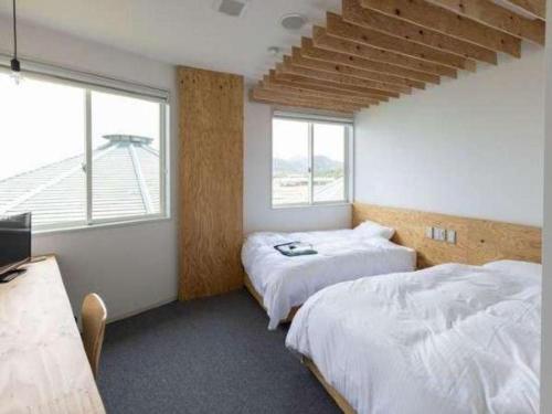 a bedroom with two beds and a window at Nest West Garden Tosa Hotel in Shimanto