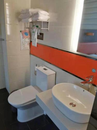 a bathroom with a white toilet and a sink at 7 Days Premium Dezhou Qingyun Nanhuan Building Materials Market in Dezhou