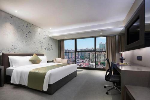 a hotel room with a bed and a desk and a window at Yongzhou Chuang Fa Cheng XiaoXiangYi Hotel in Guzhuting