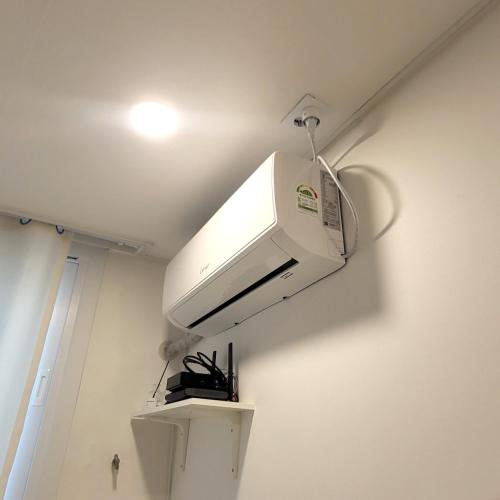 a white microwave hanging from the ceiling of a room at Humming stay in Seoul