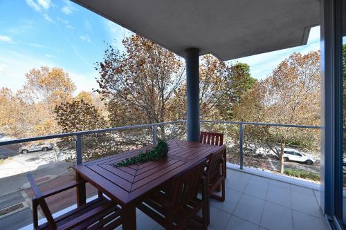 a porch with a wooden table on a balcony at Capri on Flinders in Rockingham